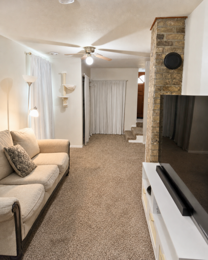 The comfortable main-floor living room features newer carpeting, abundant natural light and a charming exposed-brick accent.