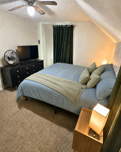 Another view of the primary bedroom highlights its generous usable space and unique upper-level character.