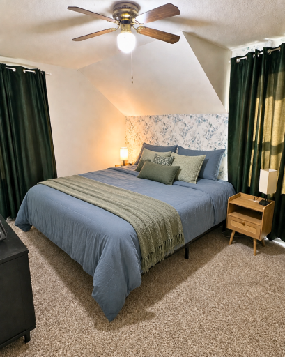 Spacious primary bedroom with newer carpeting, abundant natural light and room for a king-sized bed and additional furnishings.
