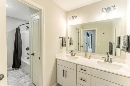 Upper level full bath. Dual sink vanity and door to separate stool and tub.