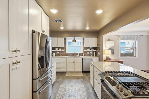 The completely updated kitchen, renovated in 2022, is designed to impress with stainless steel appliances, sleek finishes, granite countertops, and ample cabinet and prep space.