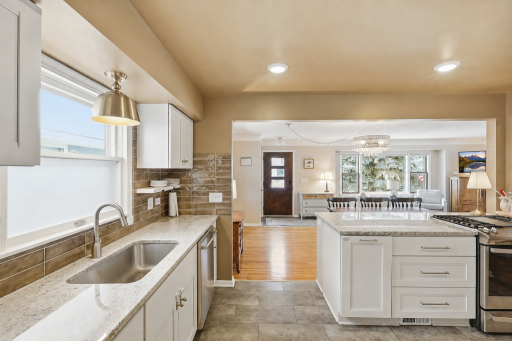 Sunlight fills the open main living spaces, highlighting beautiful hardwood floors and creating a warm, inviting feel from the moment you step inside.