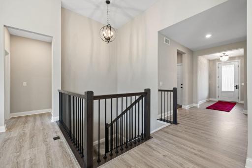 Step inside to an open, light-filled foyer featuring beautiful light wood floors and contemporary finishes