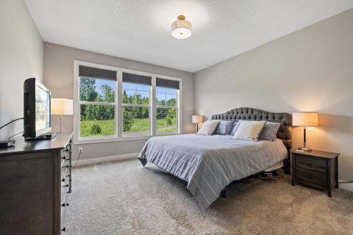 Primary bedroom has picture windows offering beautiful views of the backyard