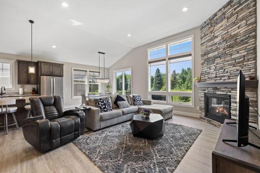 Beautiful living area with floor-to-ceiling windows and a eye-catching stone fireplace