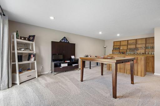 Versatile family room with ample space for a bar or kitchenette addition (virtually staged to illustrate the potential)