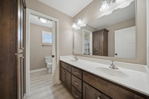 Upper level full bath with toilet room separate from double sinks.