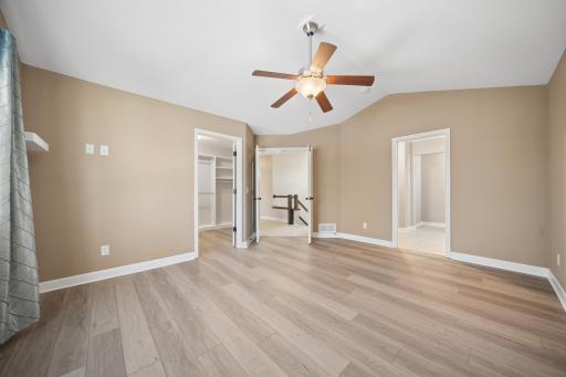 Primary bedroom with new flooring and vaulted ceilingss
