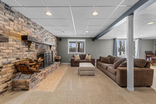 Brick feature wall spanning the length of the family room with fireplace adds warmth and charm
