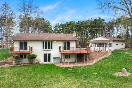 The back of the home features two decks, a patio, and a sunroomâperfect for enjoying the expansive yard and peaceful setting