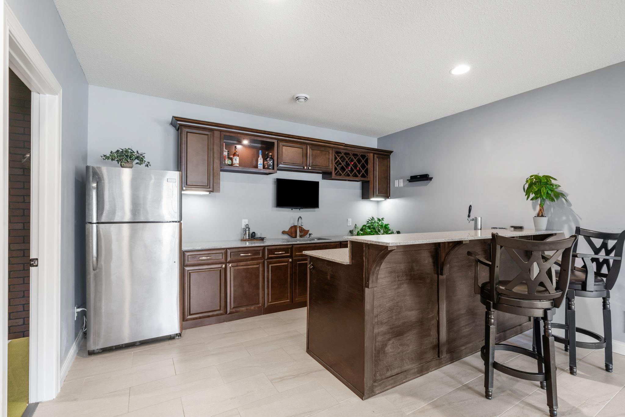 Walk-out LL features spacious Wet Bar with quartz counters, abundant cabinetry, refrigerator & kegerato