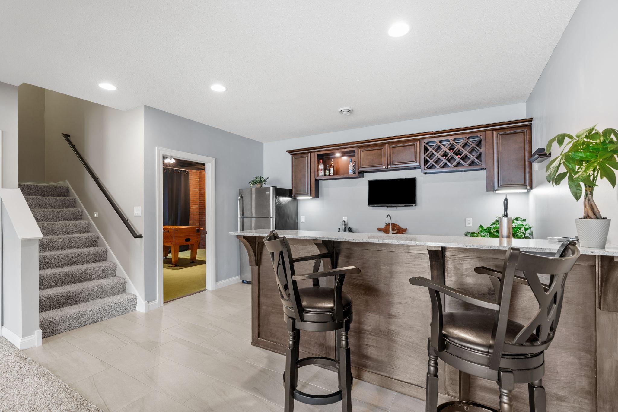 Walk-out LL features spacious Wet Bar with quartz counters, abundant cabinetry, refrigerator & kegerato