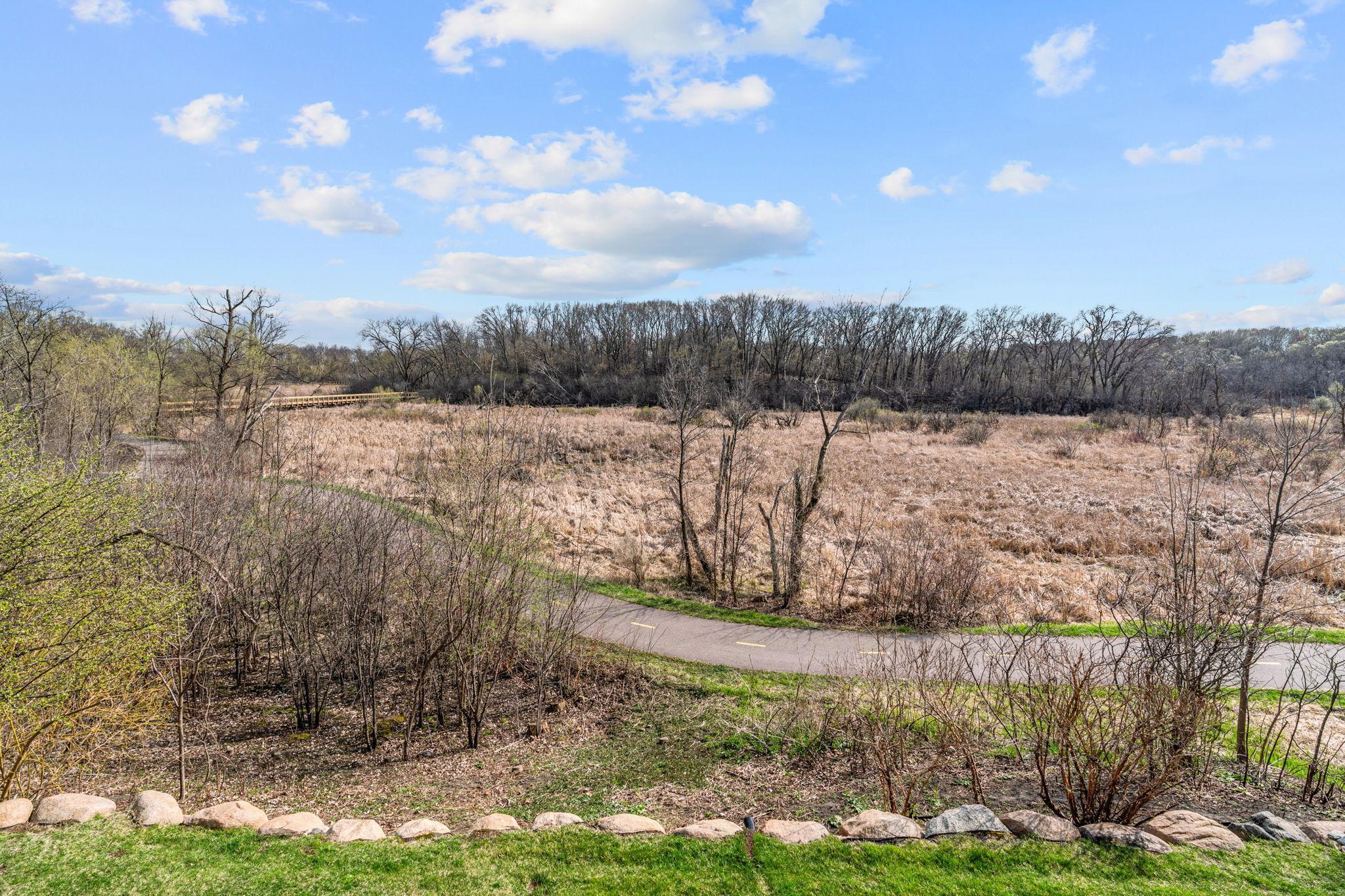 Overlooks private backyard with stunning wetland views & direct access to the Greenway