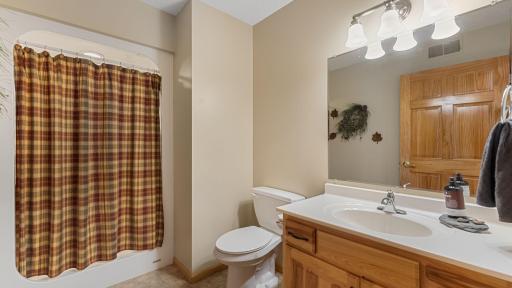 3/4 bathroom with a large vanity is located next to the main floor laundry for a guest bath.