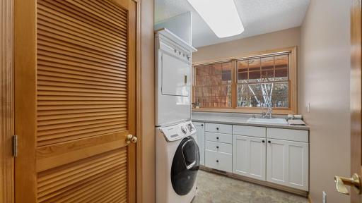 Main floor finished laundry room with a sink, storage, and cabinetry. This space overlooks the front covered porch.