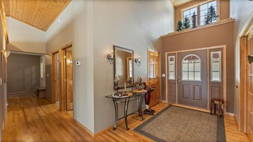 Warm well lit welcome in this foyer that has vaulted ceilings and beautiful Anderson windows allowing for morning sun to cascade in.