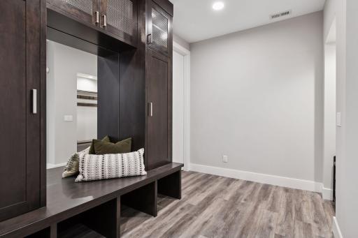Entering from the garage you are greeted by a handsome built-in with bench, shoes storage and more.