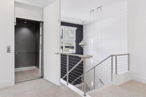Elevator on the top floor just outside of bedrooms. Custom designed sconces in main hallway and another view of three level lighting.
