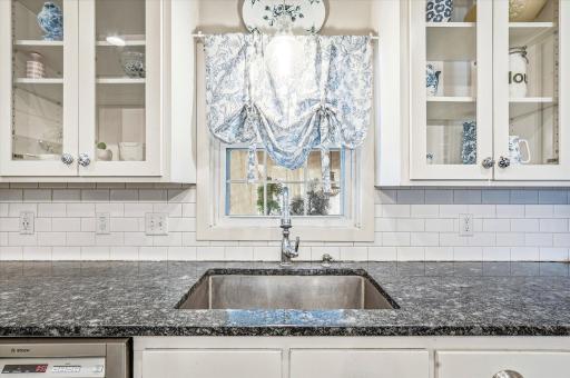 Granite countertops with recessed sink and a view to the backyard