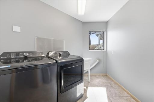 Dedicated laundry room with utility sink and natural light.