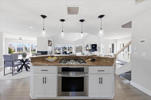 Large center island with cooktop and breakfast bar, perfect for gathering and everyday living.