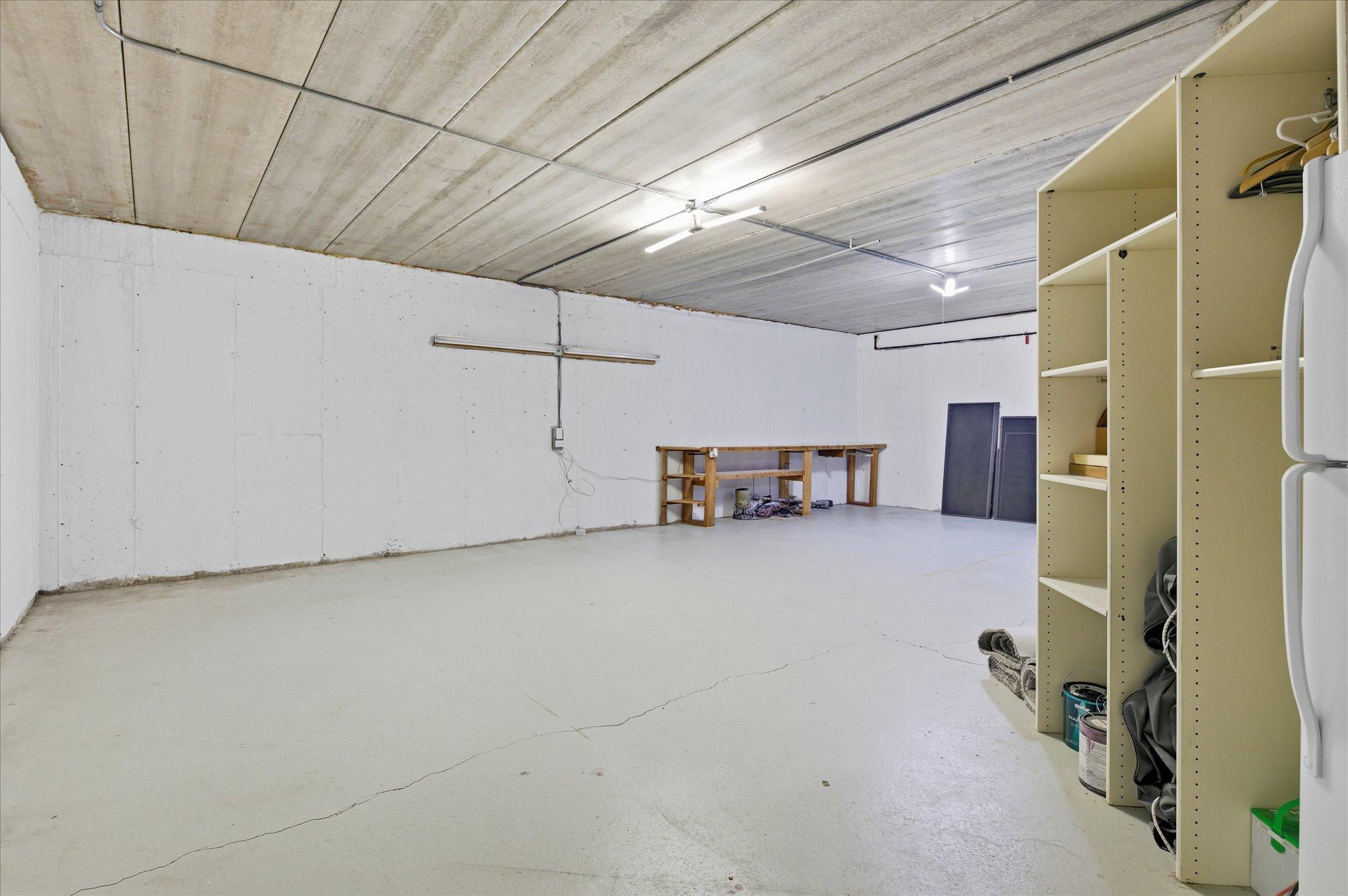 Additional unfinished lower-level space with workshop setup and utility access.