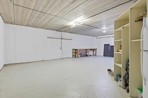 Additional unfinished lower-level space with workshop setup and utility access.