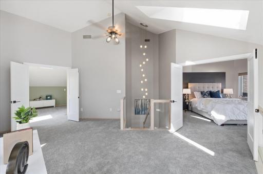 Upper-level overview showcasing open staircase, loft area, and private suite access.