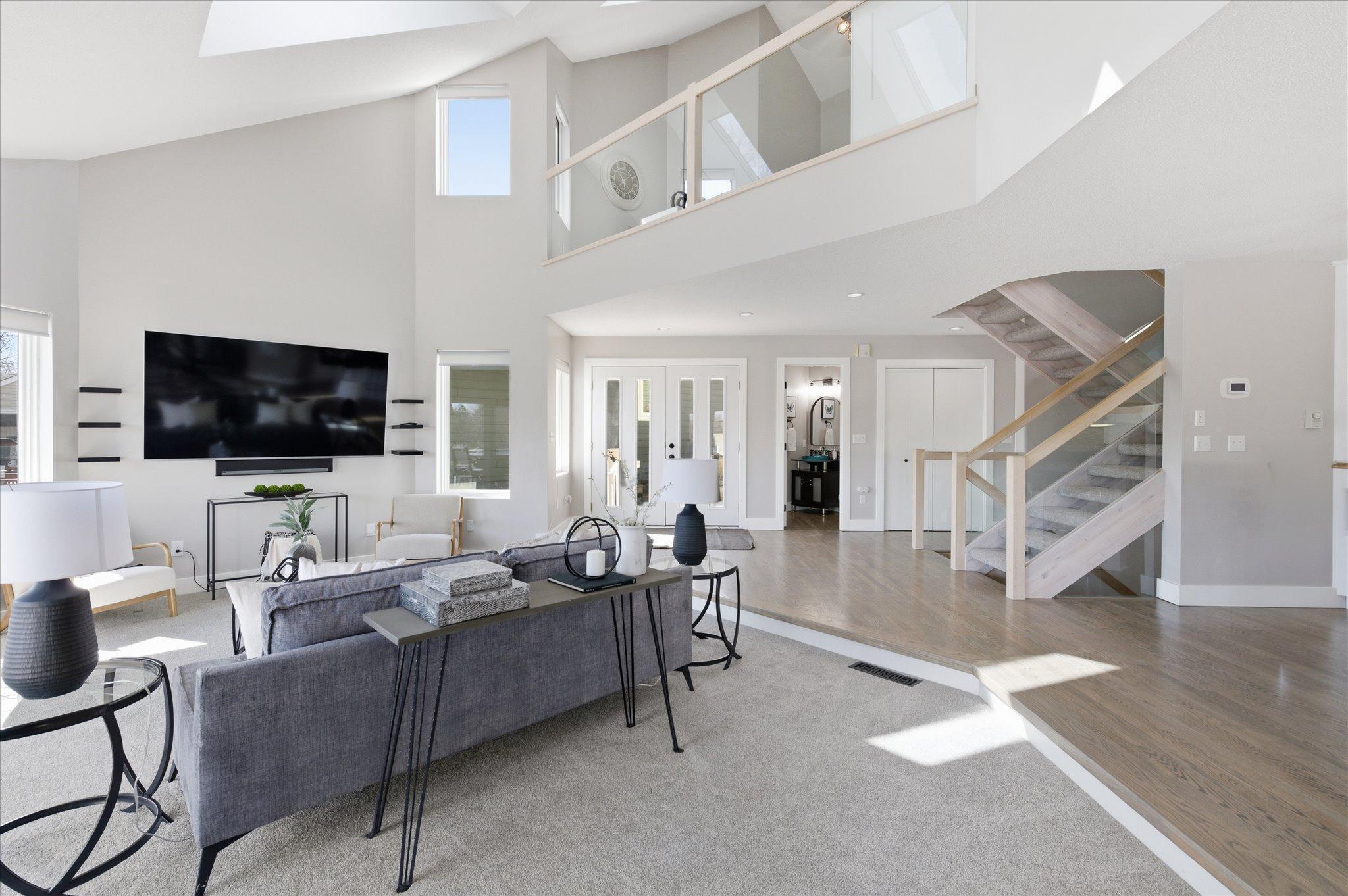 Elevated loft overlook with glass railing, enhancing openness and architectural appeal.