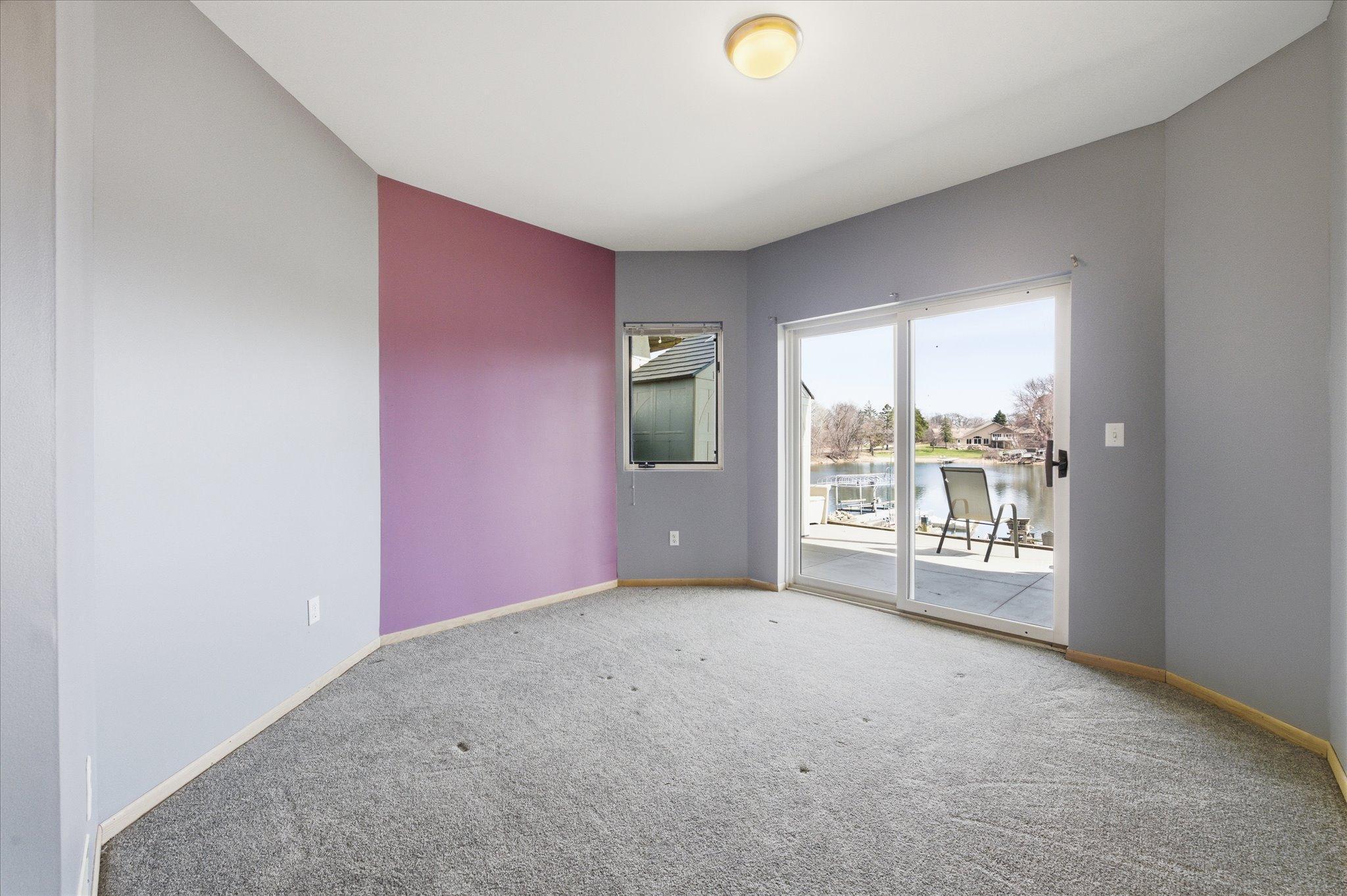 Additional lower-level bedroom with sliding door access to patio and lake views.