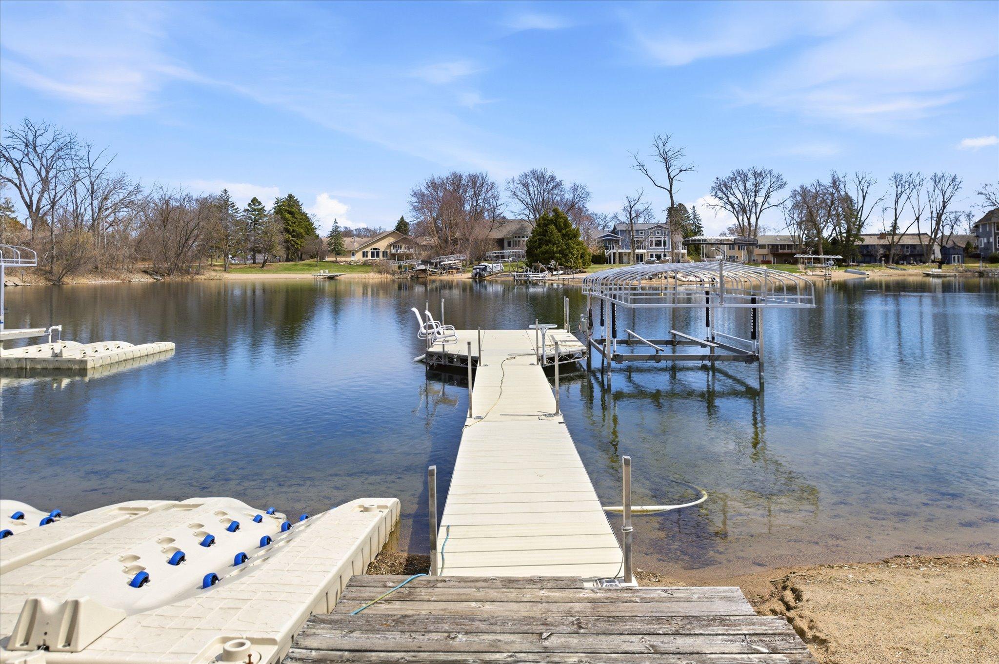Private dock extending into the lake with clear water and space for boating and entertaining.