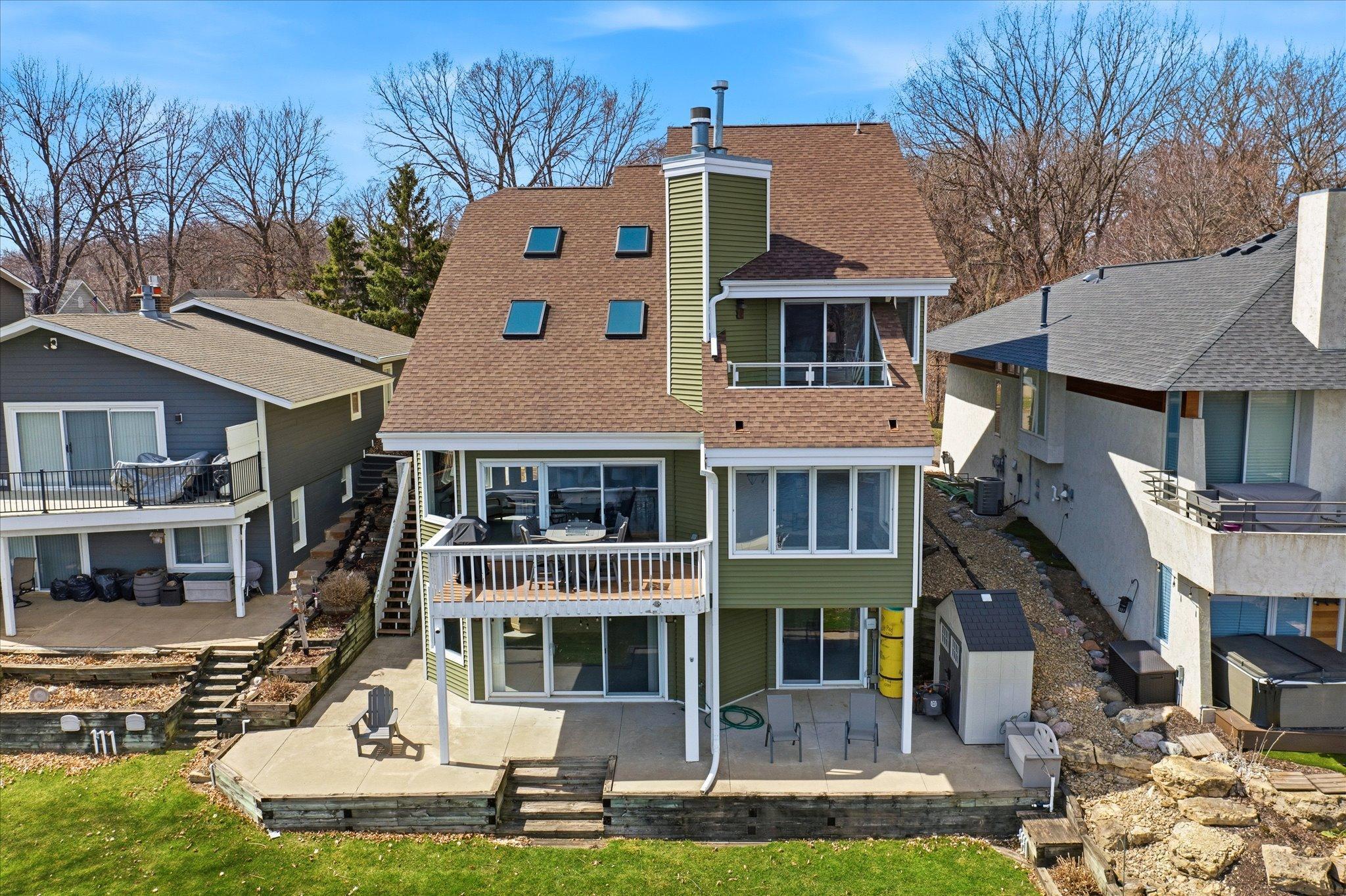Rear exterior with multi-level decks and walkout lower level, designed to maximize lake views.
