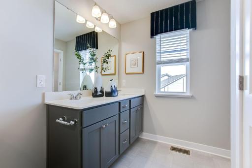 The primary ensuite bathroom complete with quartz counter top vanity and dual sinks. *Picture is of model home; actual finishes may vary.