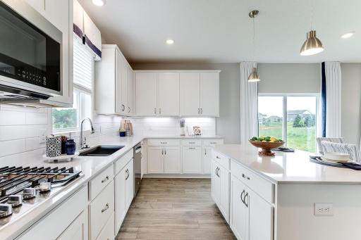 The signature kitchen in the Jordan floorplan is beautifully designed & includes quartz countertops, tile backsplash, double wall ovens & a huge walk-in pantry. The kitchen is a chef's dream & provides ample space for your culinary needs.