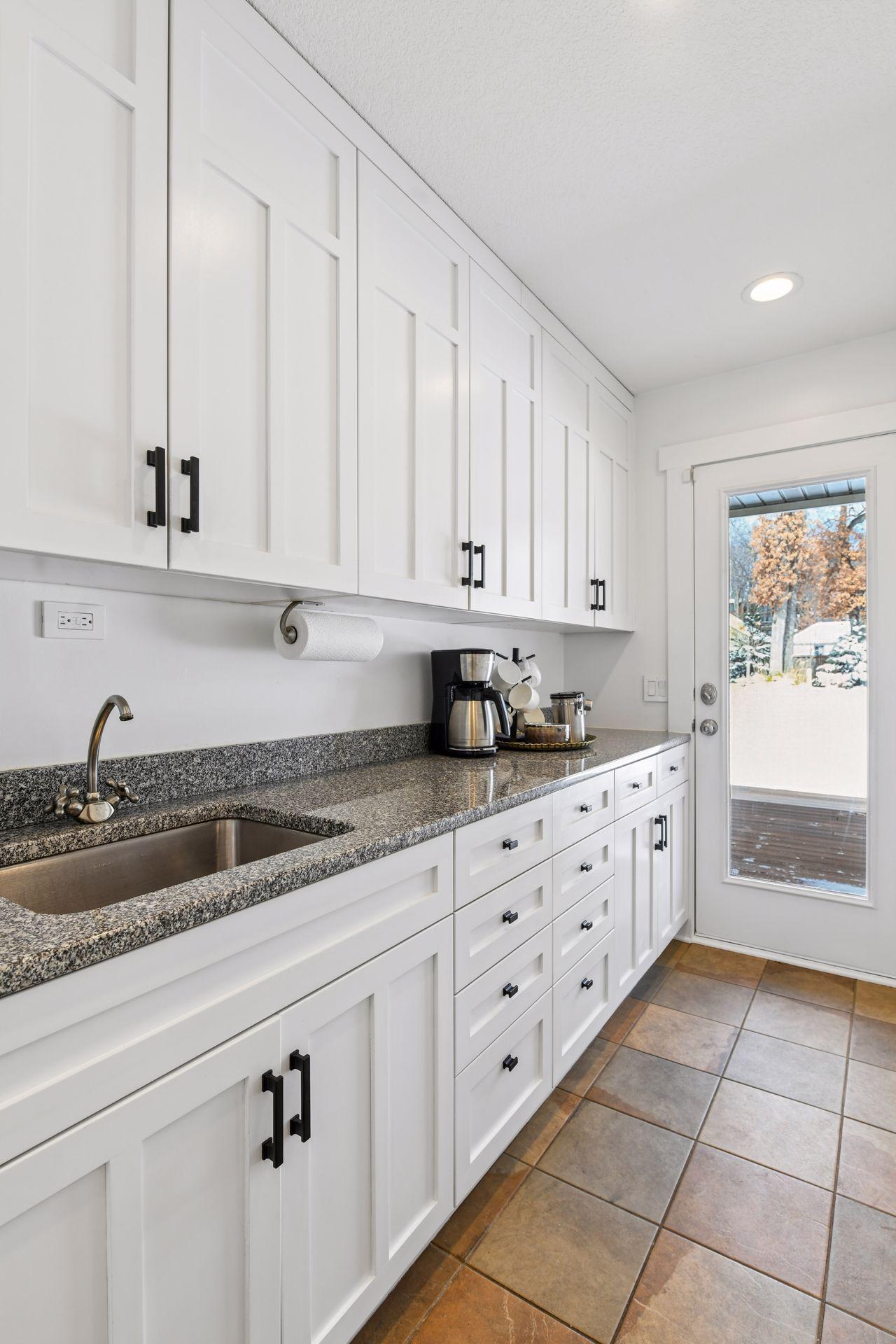 Upper level laundry room/pantry with access to the backyard