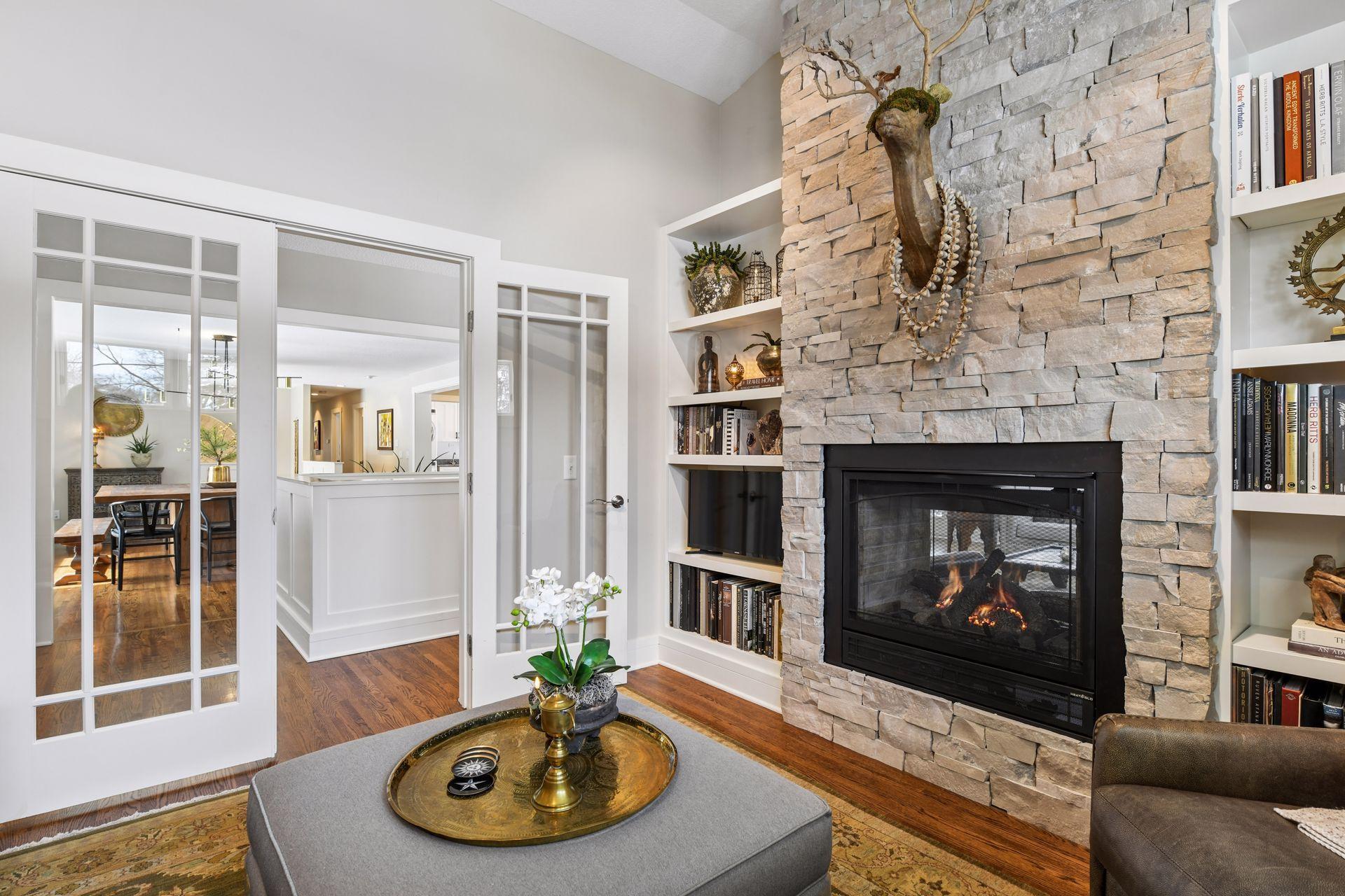 Cozy den with 2-sided gas fireplace, which has an updated stone surround