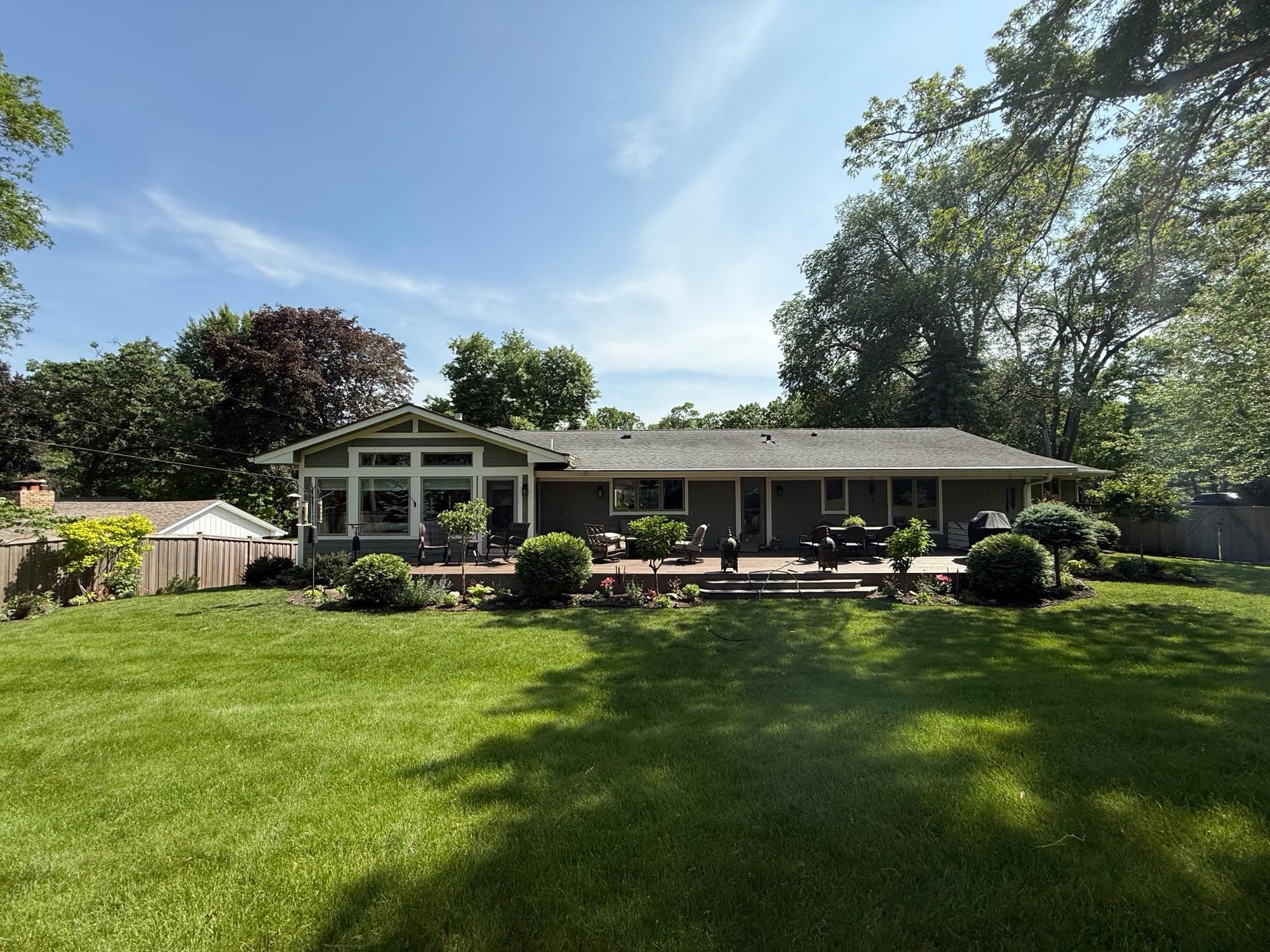 Welcoming deck surrounded by mature trees and curated landscaping