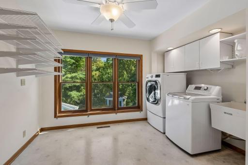 Spacious upper-level laundry room filled with natural light and offering ample storage.