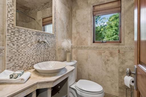 Main-level full bathroom featuring beautiful, ornate tilework and timeless details.