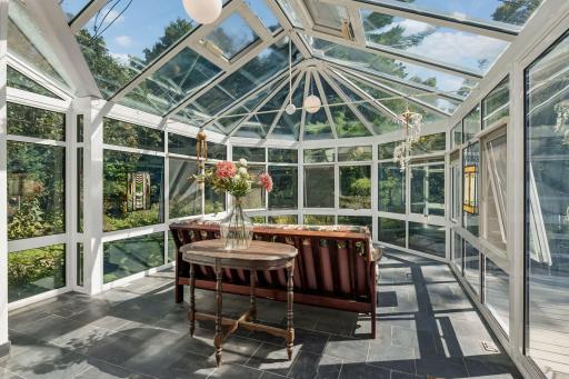Breathtaking solarium with serene backyard views, beautiful slate flooring, and an abundance of natural light.