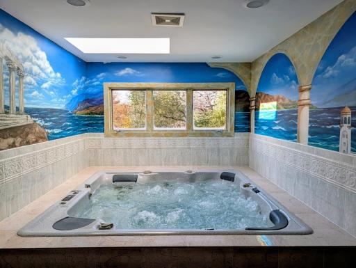 Step into a relaxing hot tub surrounded by beautiful tilework and natural light from the skylight.