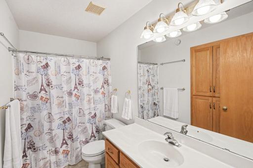 The full bathroom on the upper level features: an oversized vanity, a built-in storage cabinet, and a exhaust fan.