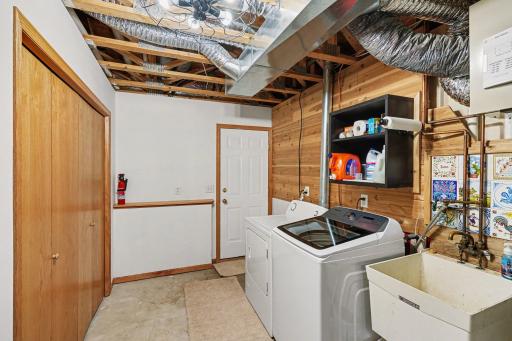 The lower level laundry/utility room features: a storage closet, newer washing machine, water softener (owned), a 50 gallon AO Smith water heater, and access to the attached 3 car garage.