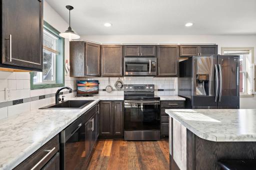 The kitchen features a wide, deep sink, perfect for washing up large pots and pans after a meal! The tasteful tile backsplash brightens the space.