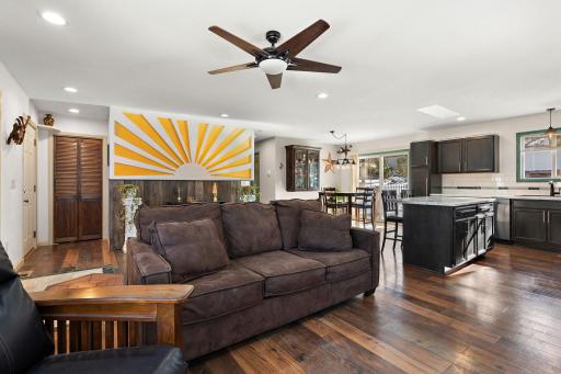 A view of the dining area and kitchen from the living room. The backyard can be seen through the patio doors across the room.