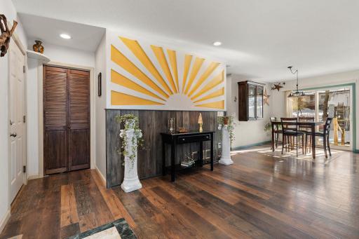 Front foyer with garage door access on the left and coat closet and the dining area across the room. Note the beautiful floors!