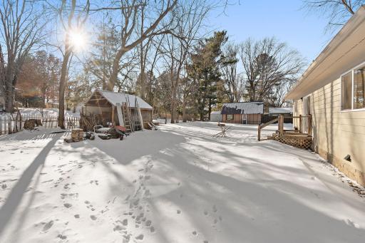 A view of the backyard storage shed and back of the house from the opposite end of the yard.
