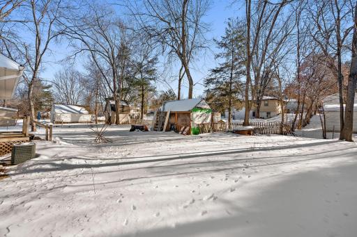 The backyard features some light tree coverage and a yard shed for storing lawn equipment.