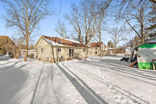 A view of the back of the home from the corner of the backyard.