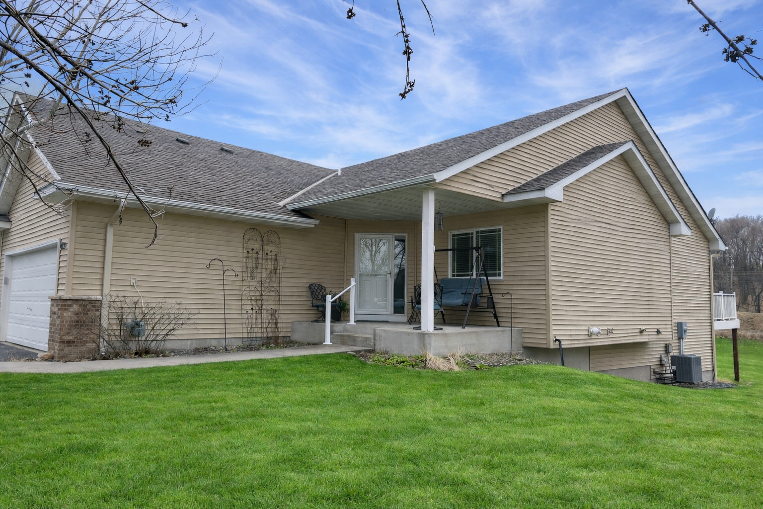 Spring photo of the side of home. The covered porch is a great place to relax.